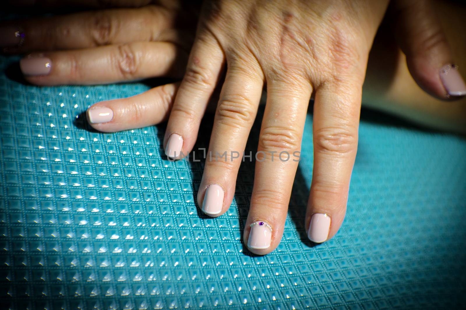 Womans hands showing semi-permanent beige manicure