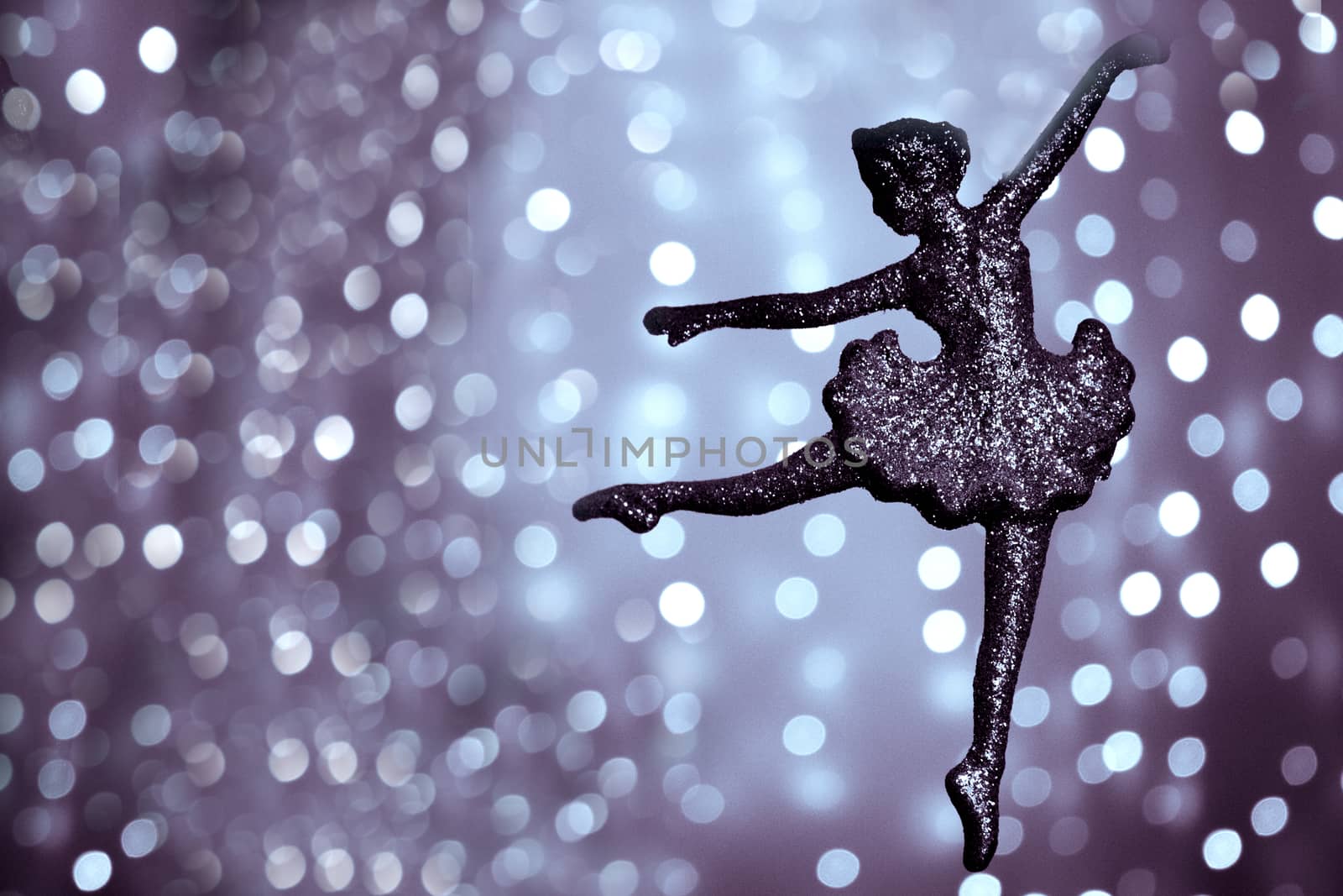 Silhouette of ballet dancer on bright bokeh background