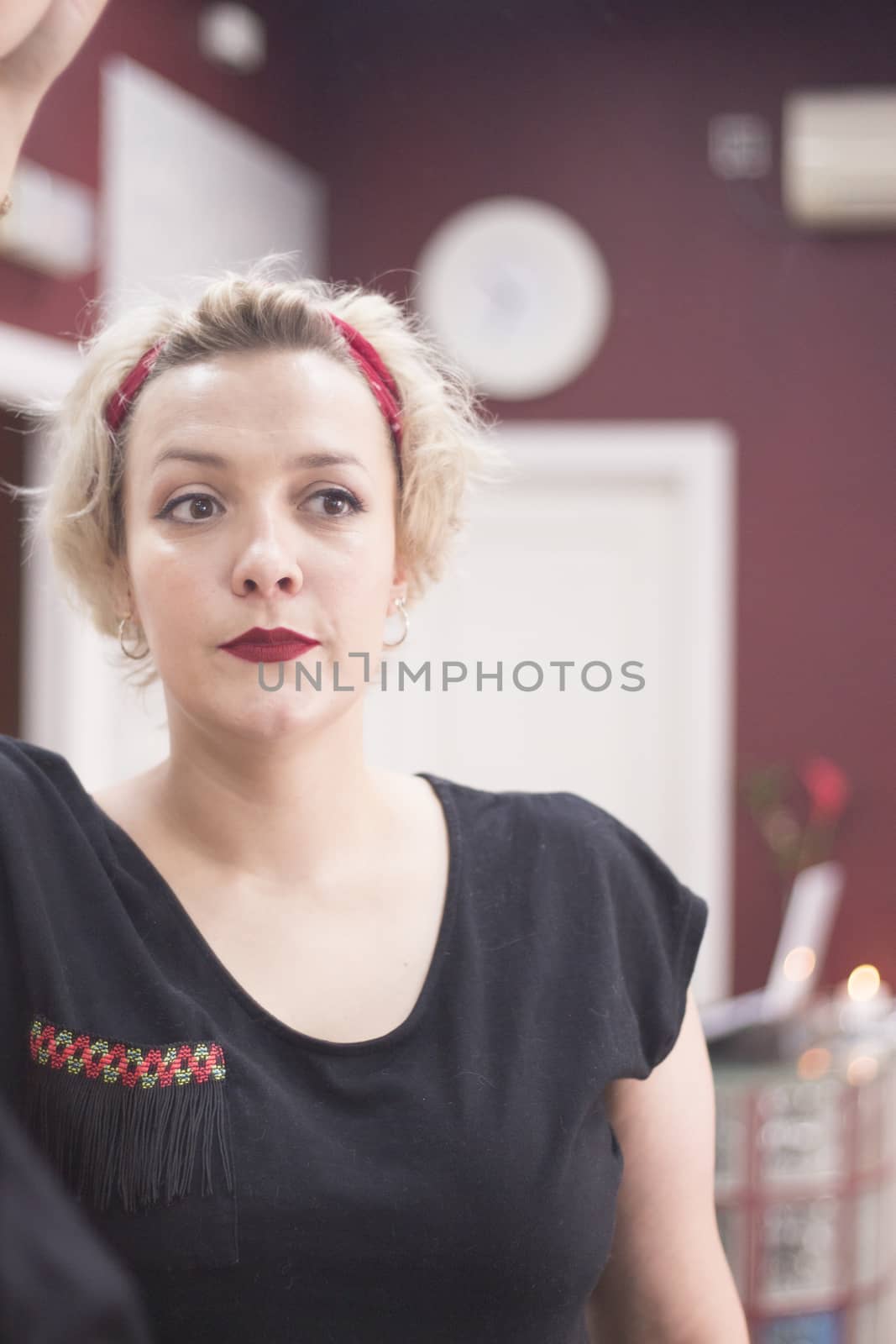 Portrait of blonde woman with short hair and pinup style. Relaxed expression