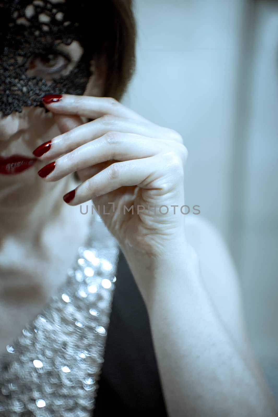 Elegant dressed woman hiding her face by a mask