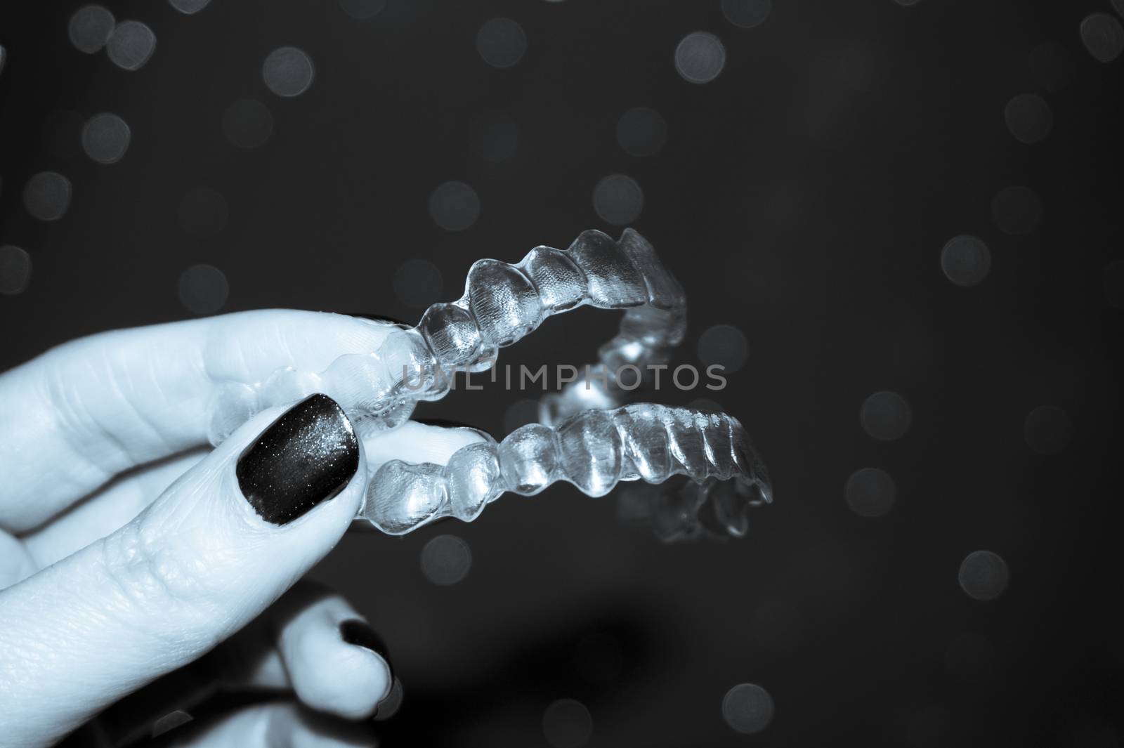 Woman hand holding denture alignment retainer