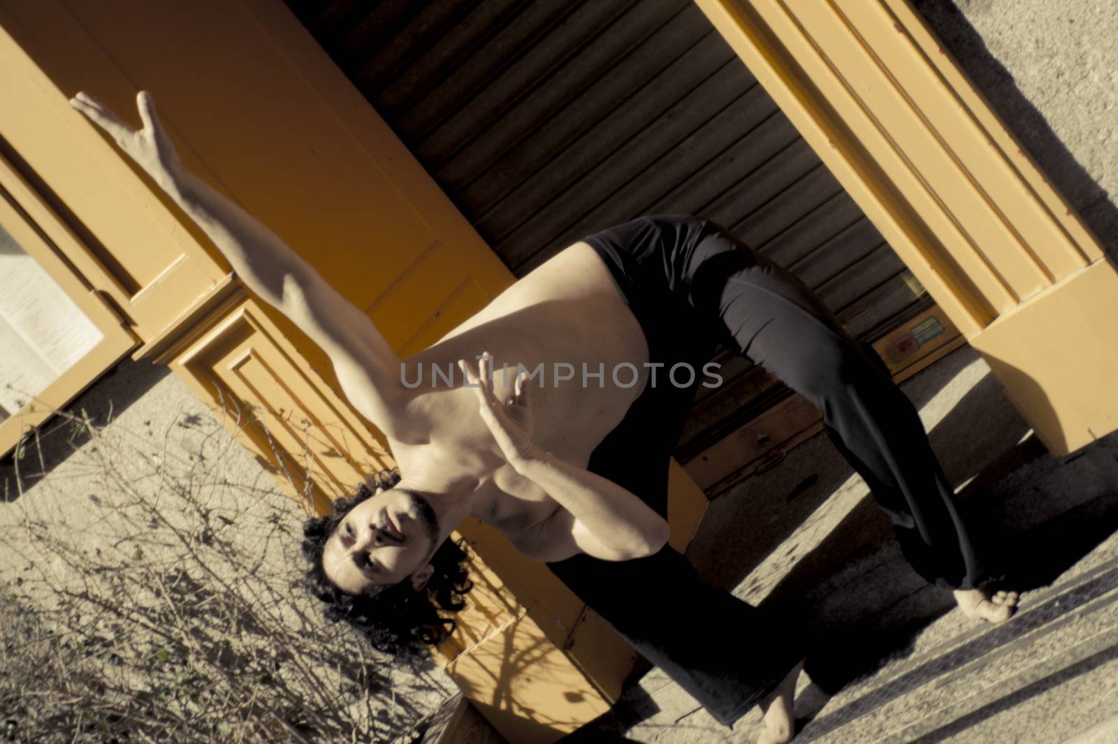 Latin male dancer posing with dancing figures. Urban background