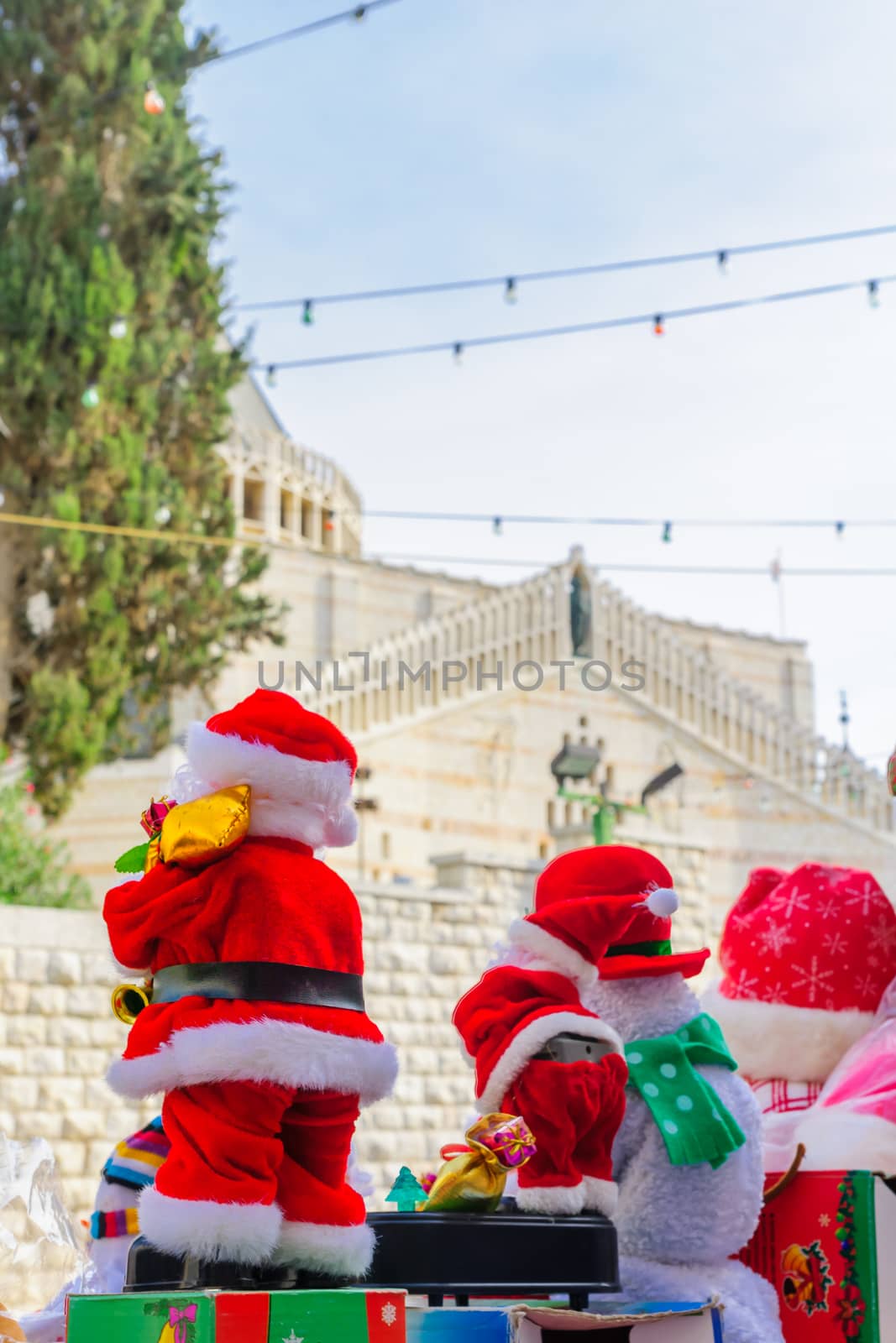Santa Claus puppets on sale, with the Church of the Annunciation in the background, in Nazareth, Israel