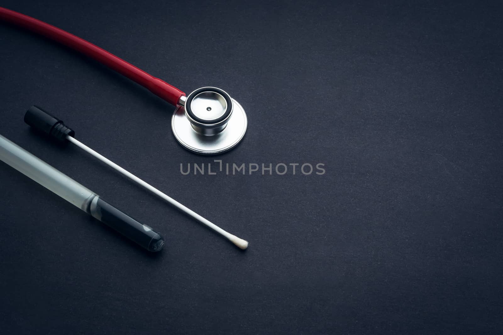 Medical swab and stethescope closeup on black background by silverwings