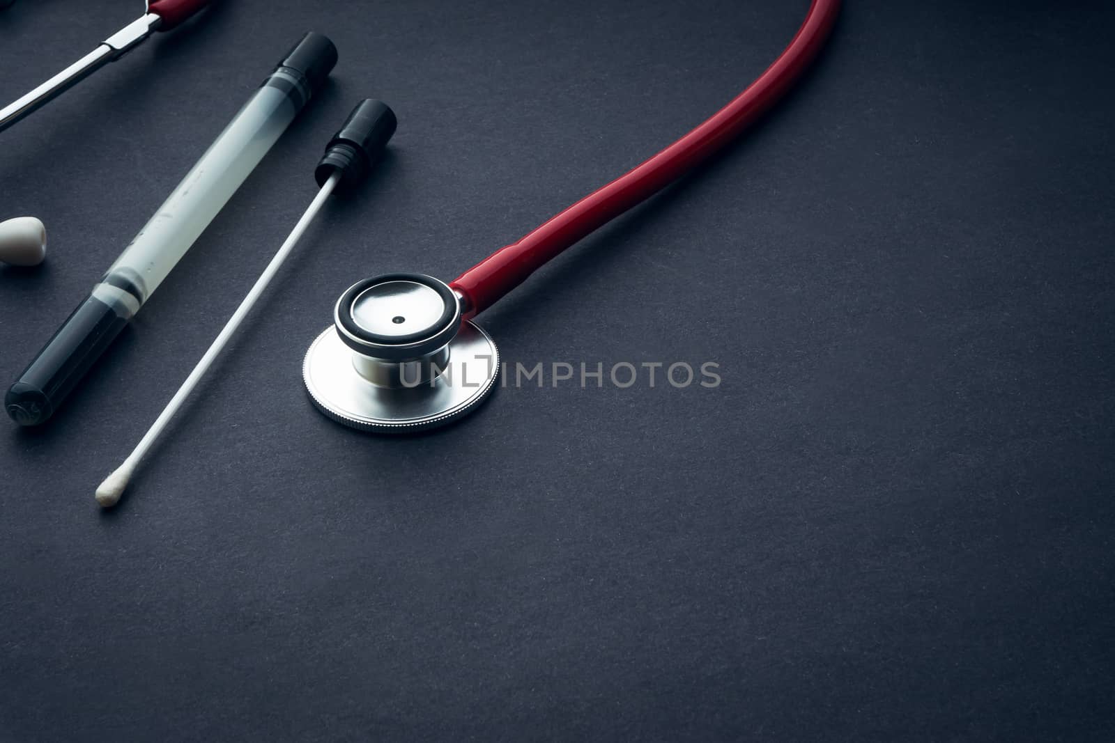 Medical swab and stethoscope closeup on black background. Health care and copy space concept