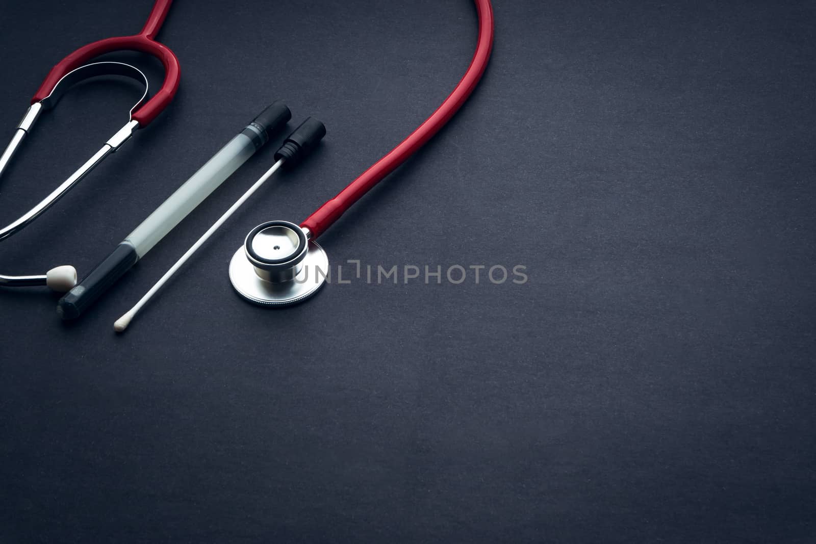 Medical swab and stethescope closeup on black background by silverwings