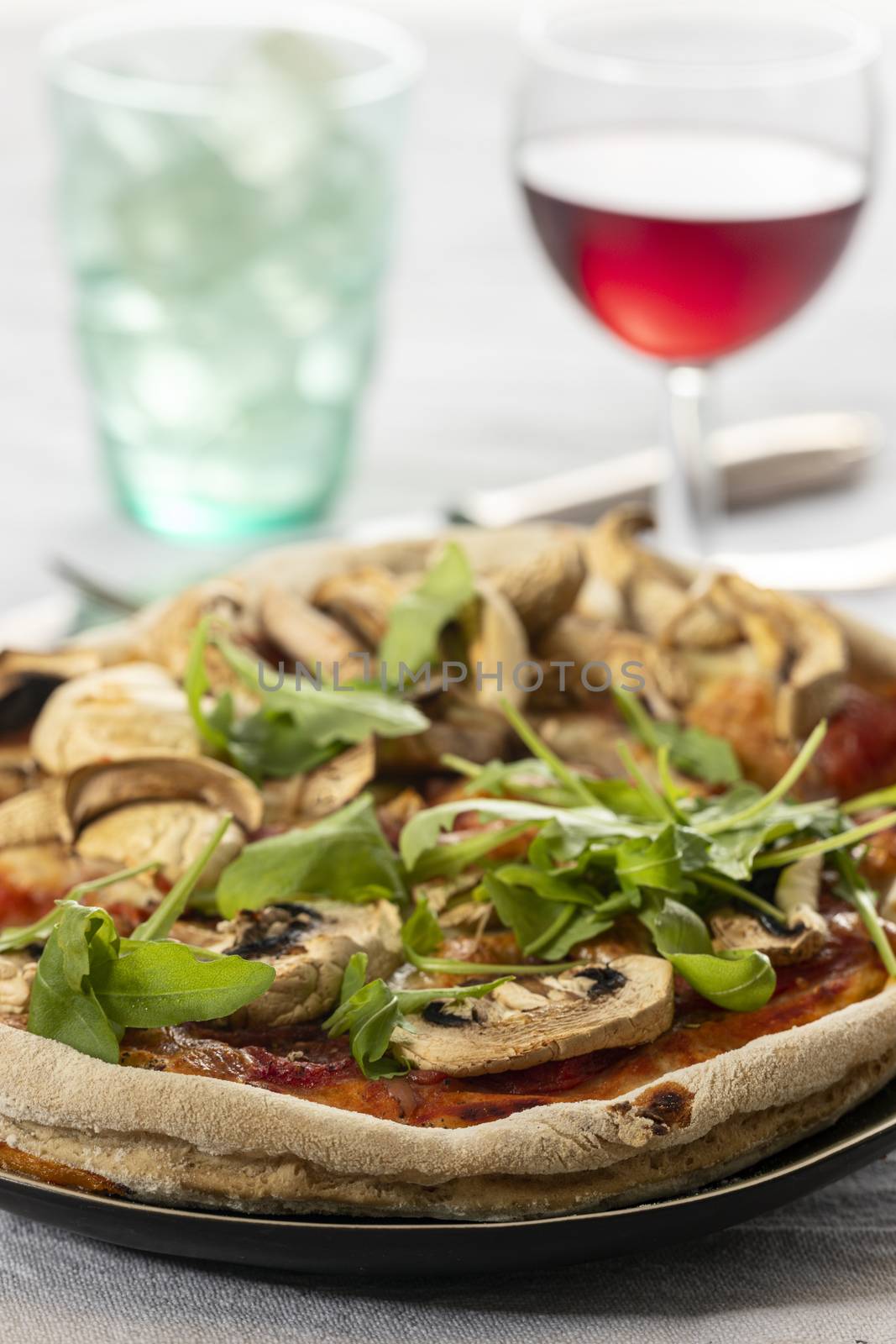 mushroom pizza on a plate with arugula by bernjuer