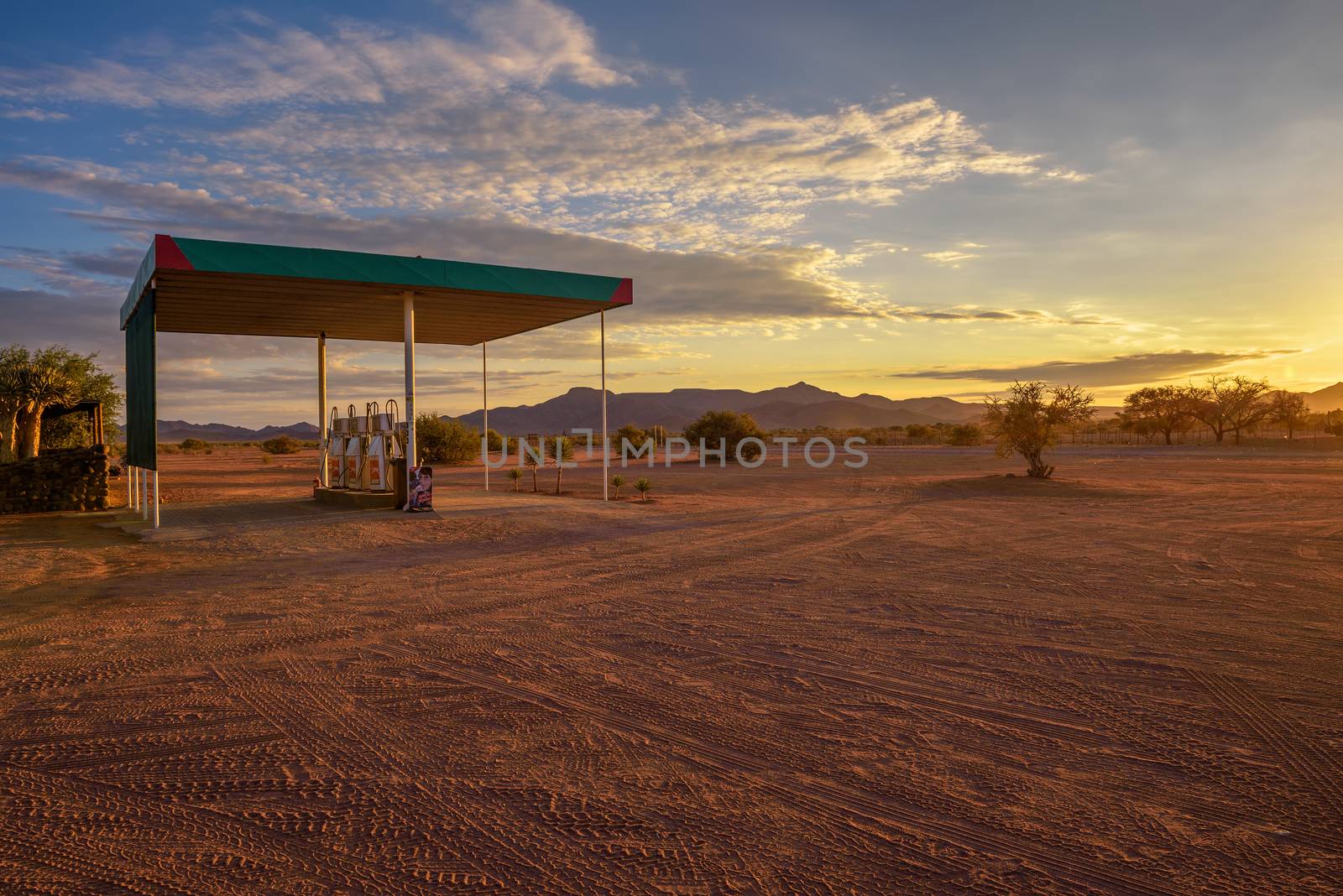 Puma gas station located on a dirt road in the Namib Desert at sunrise by nickfox