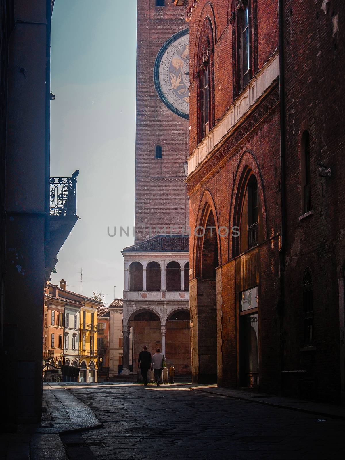 Cremona, Lombardy, Italy - May  5 6 7  2020 - man or woman walking or biking in deserted downtown  during covid outbreak lockdown phase 2