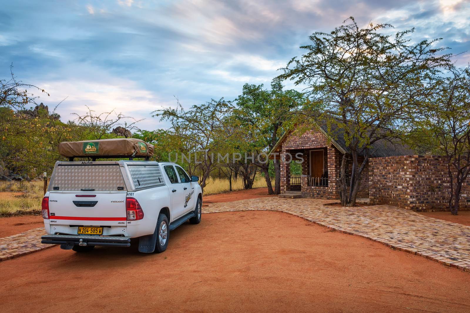 Kamanjab, Namibia - March 30, 2019 : Typical 4x4 rental car in Namibia equipped with camping gear and a roof tent parks at the Kaoko Bush Lodge located near the Galton Gate of Etosha National Park.