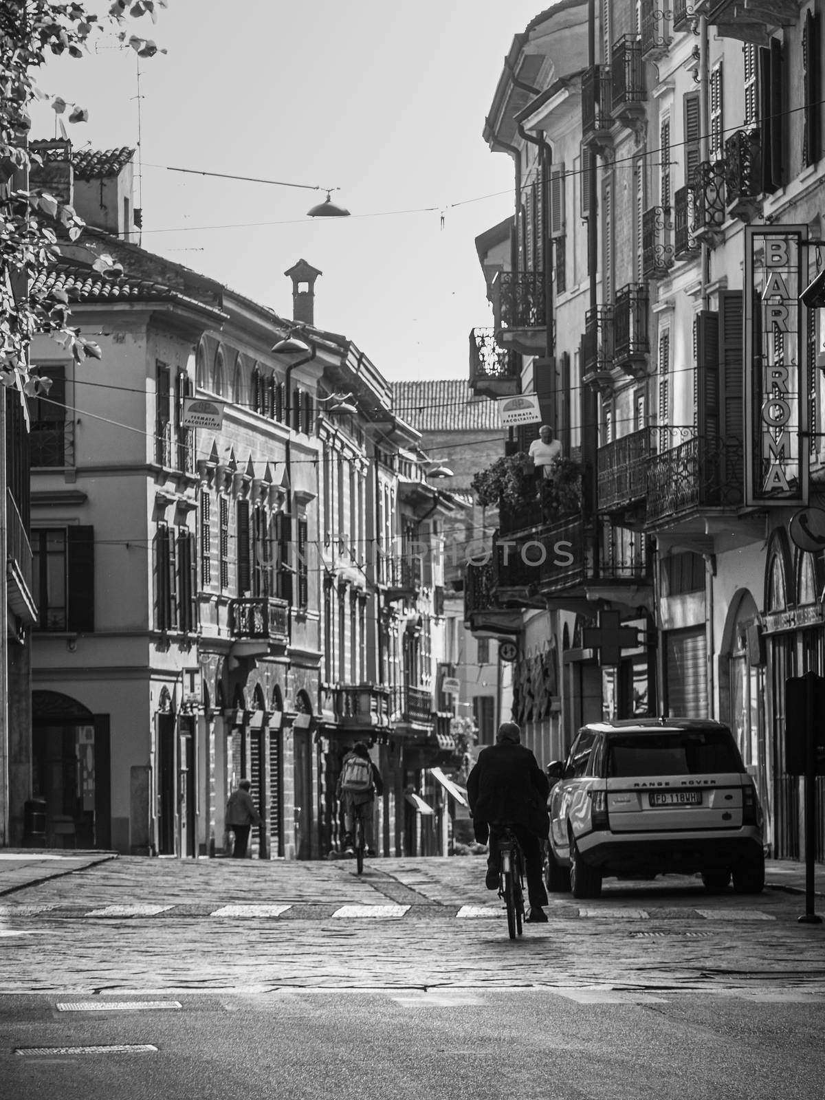 Cremona, Lombardy, Italy - May  5 6 7  2020 - man or woman walking or biking in deserted downtown  during covid outbreak lockdown phase 2