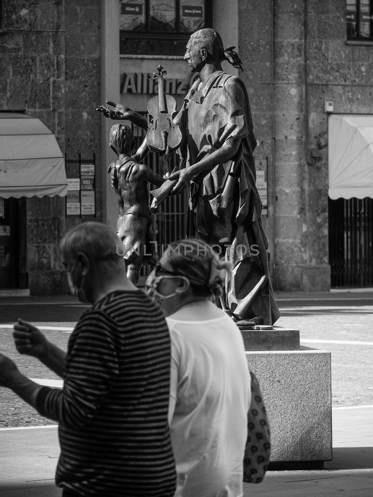 Cremona, Lombardy, Italy - May  5 6 7  2020 - man or woman walking or biking in deserted downtown  during covid outbreak lockdown phase 2