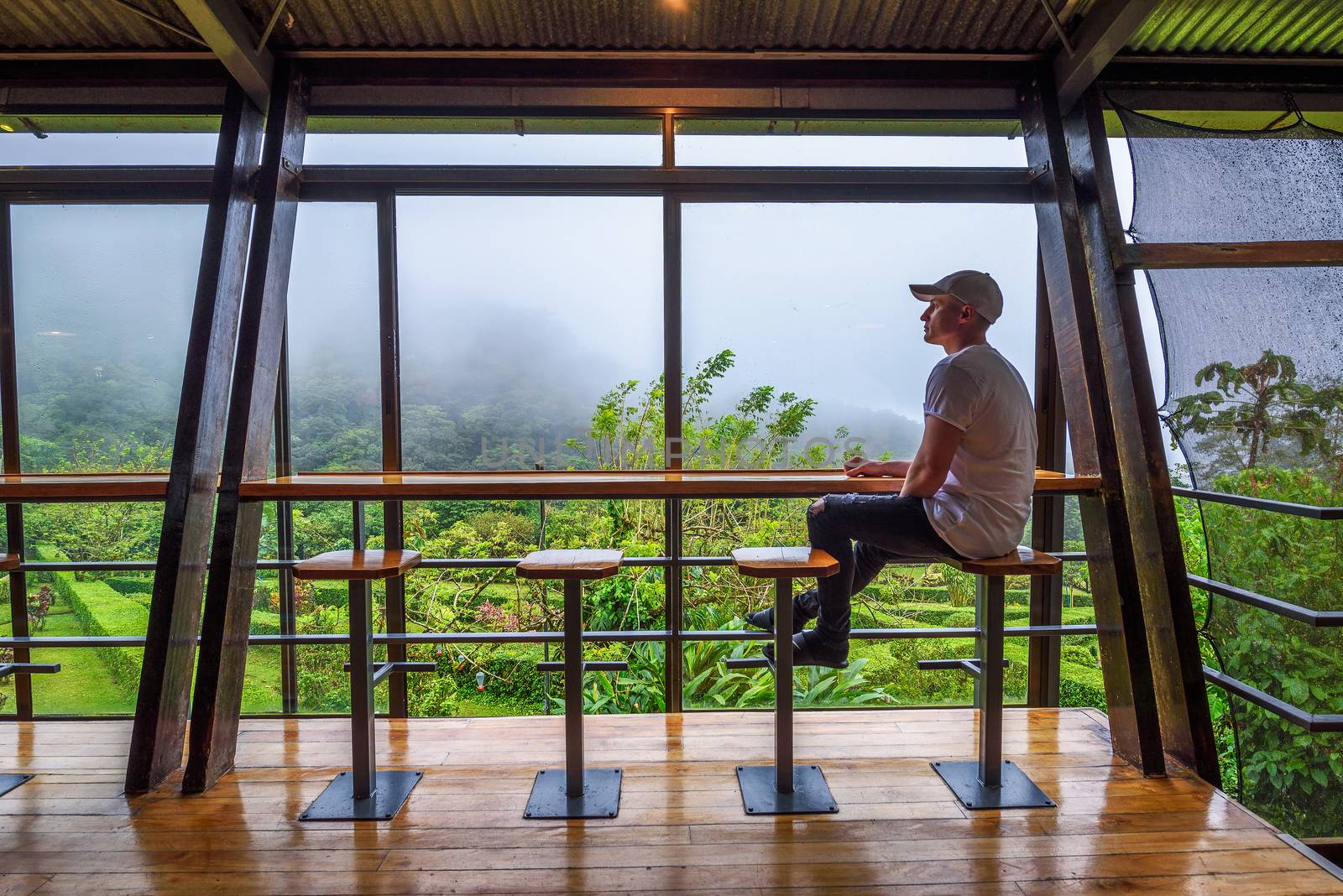 Tourist sitting in the lounge bar of Celeste Mountain Lodge in Costa Rica by nickfox