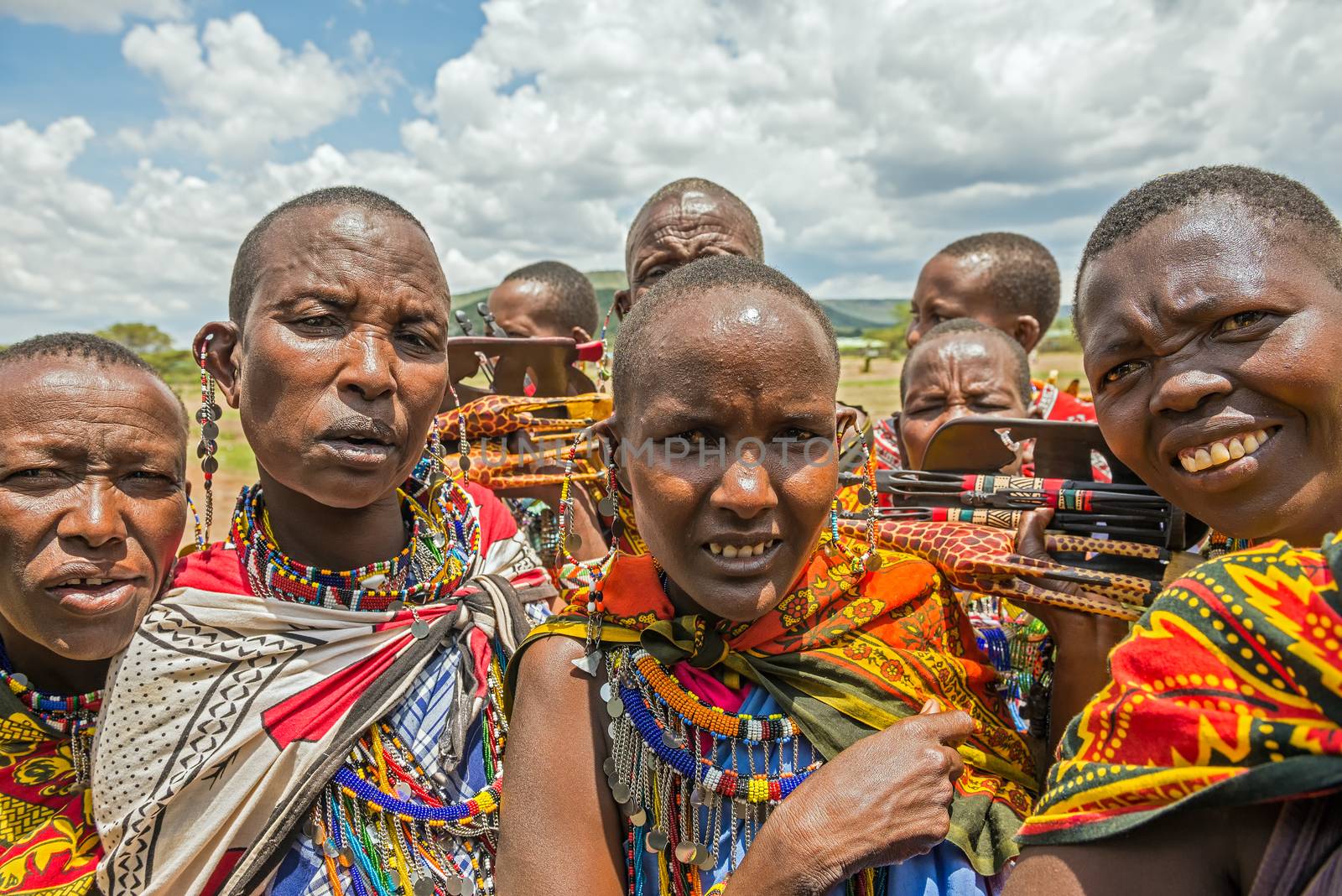MAASAI MARA, KENYA - OCTOBER 16, 2014: Group of Maasai people with traditional jewelry selling their homemade souvenirs. The Maasai are a Nilotic ethnic group of semi-nomadic people inhabiting southern Kenya and northern Tanzania.