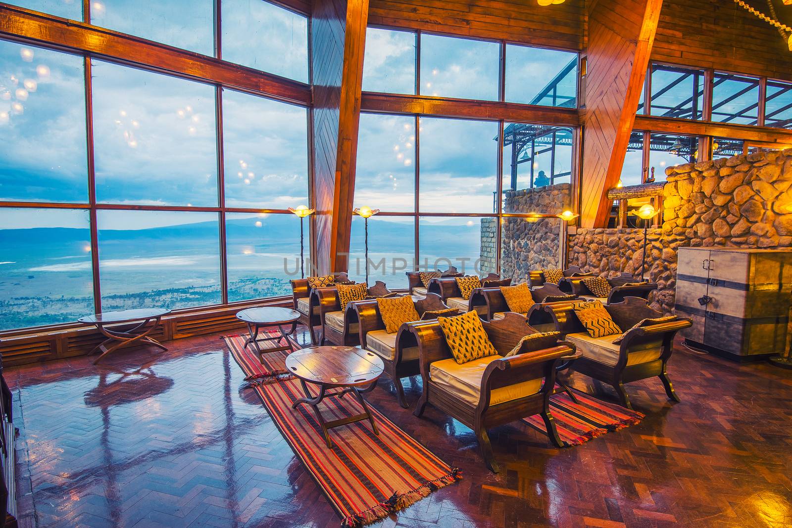 Interior of the Ngorongoro Wildlife Lodge with a glass wall overlooking the park by nickfox