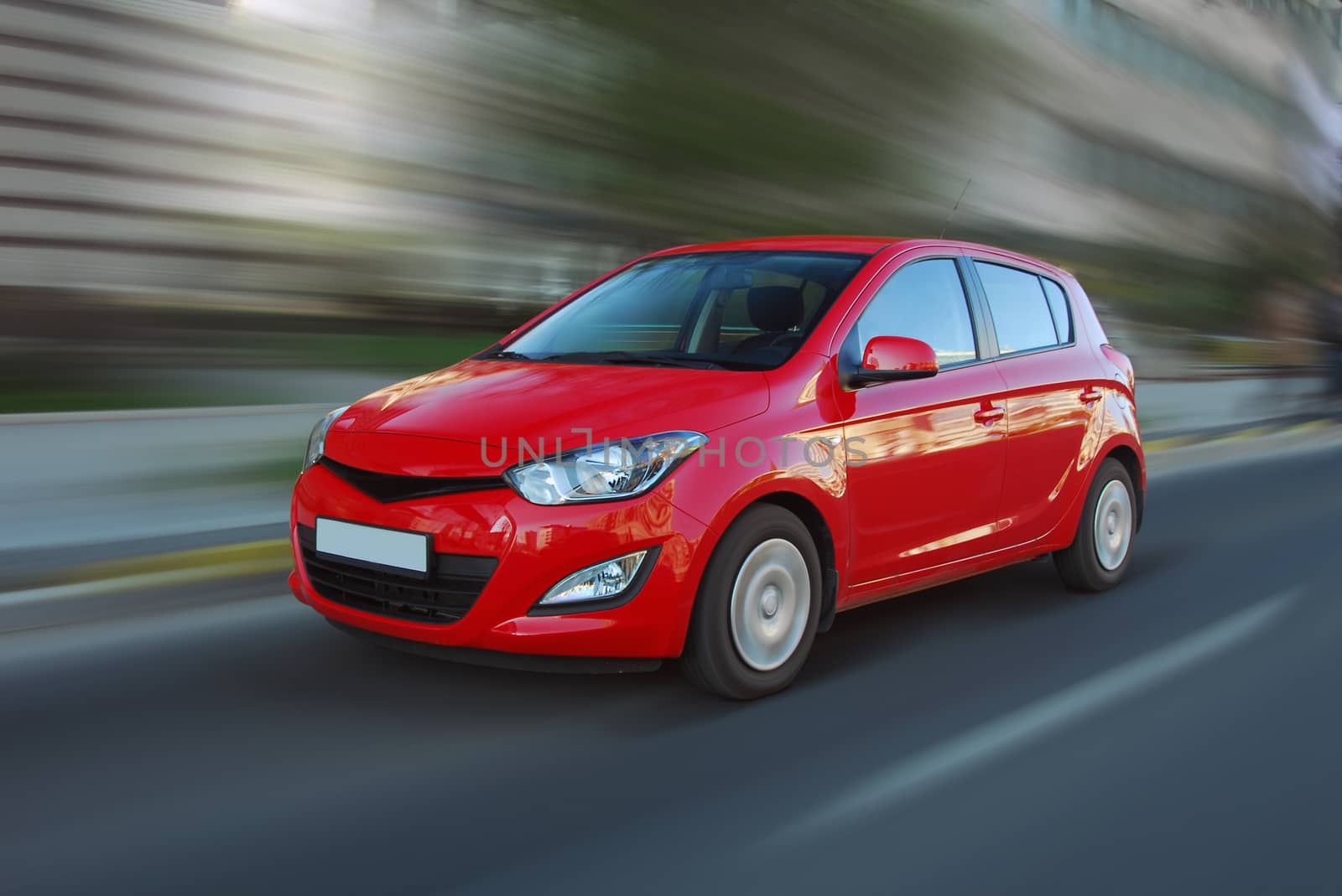 A panning shot of a speeding red car