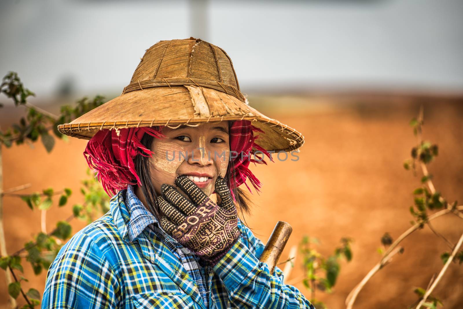 SHAN, MYANMAR - JANUARY 25, 2016 : Portrait of a young female farmer working in a field