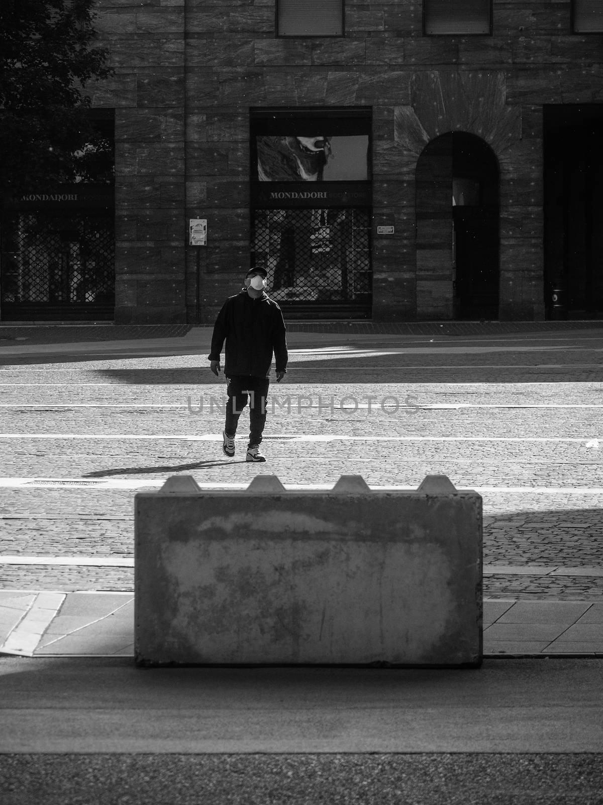 Cremona, Lombardy, Italy - May  5 6 7  2020 - man or woman walking or biking in deserted downtown  during covid outbreak lockdown phase 2
