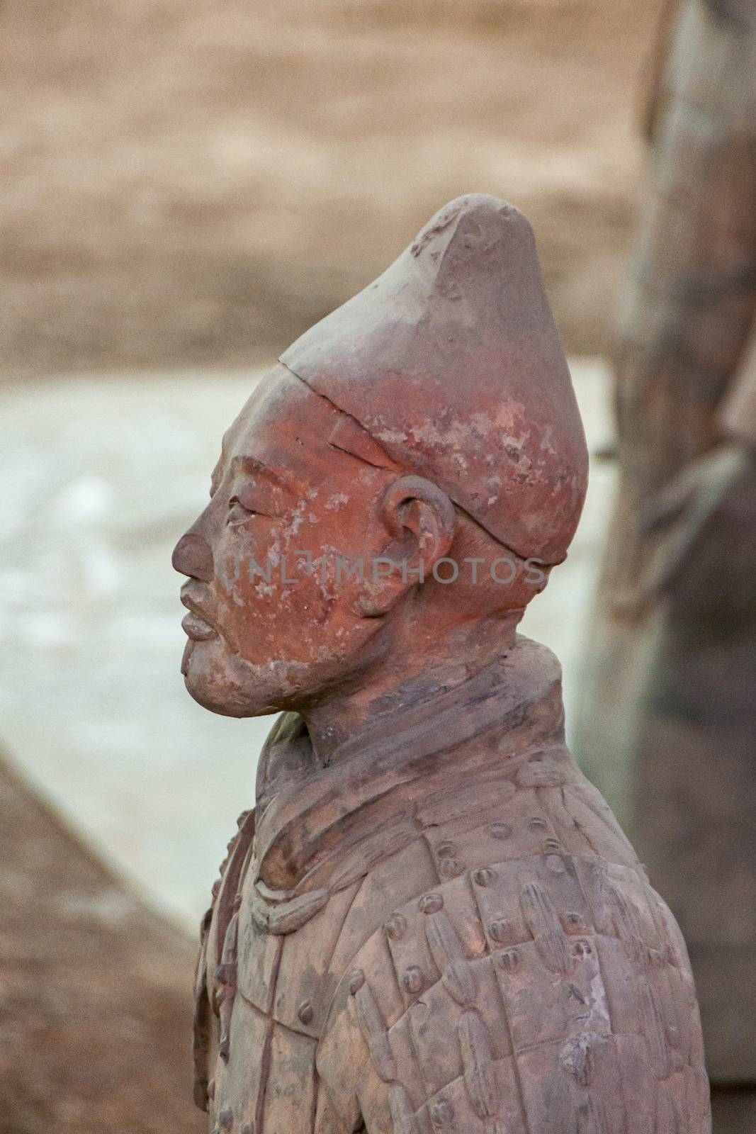 Side closeup of soldier at excavation in Terracotta Army museum, by Claudine