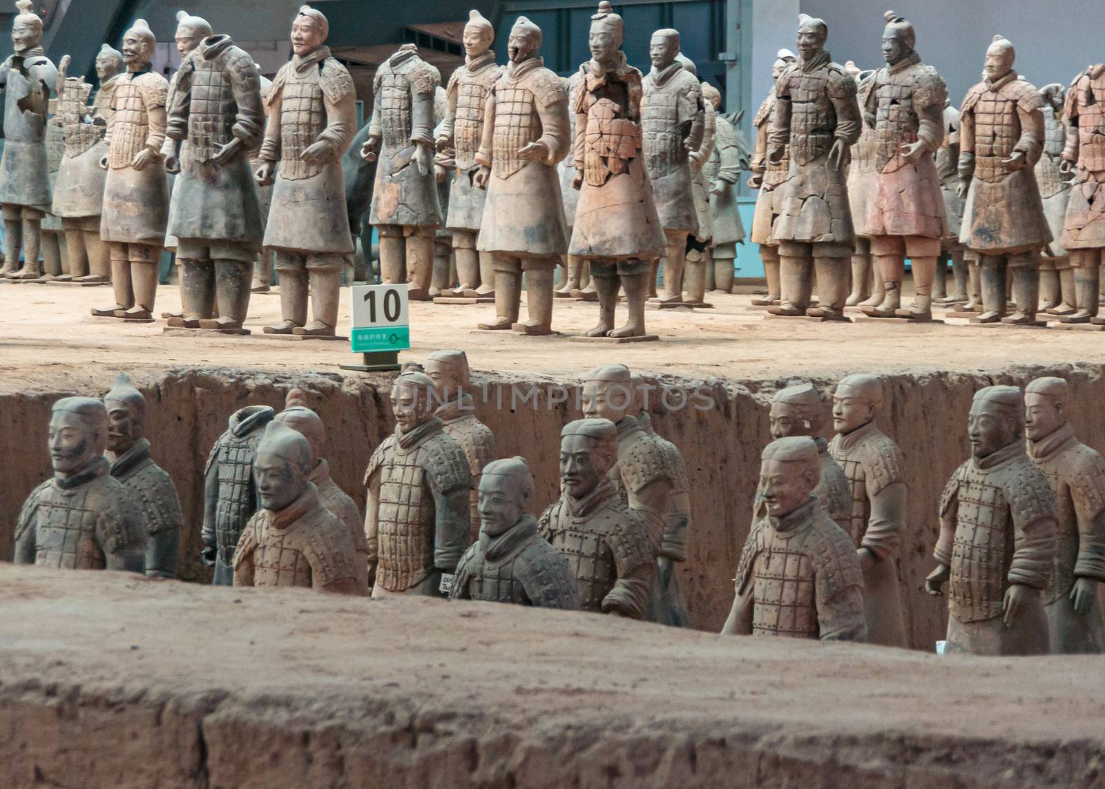 Xian, China - May 1, 2010: Terracotta Army museum and hall.  2 levels of soldier beige-gray sculptures at excavation.