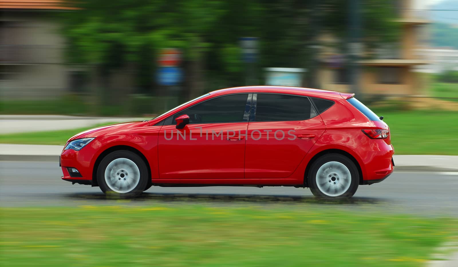 A panning shot of a speeding red car