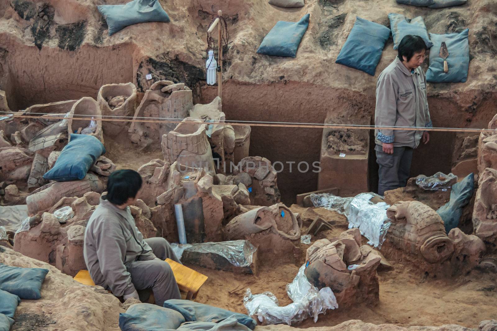 2 workers at excavation in Terracotta Army museum, Xian, China. by Claudine