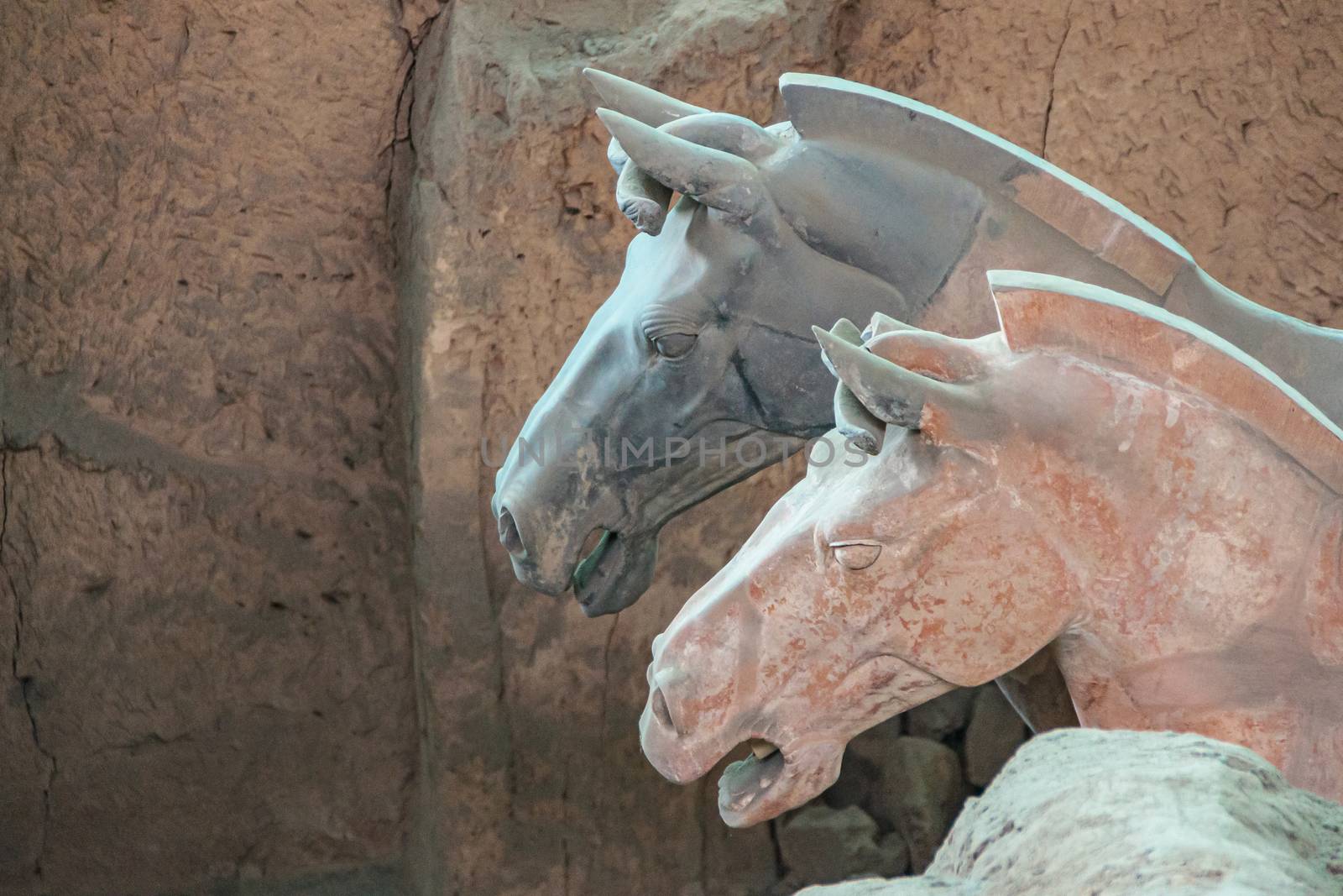 Red and gray horse heads at excavation in Terracotta Army museum by Claudine