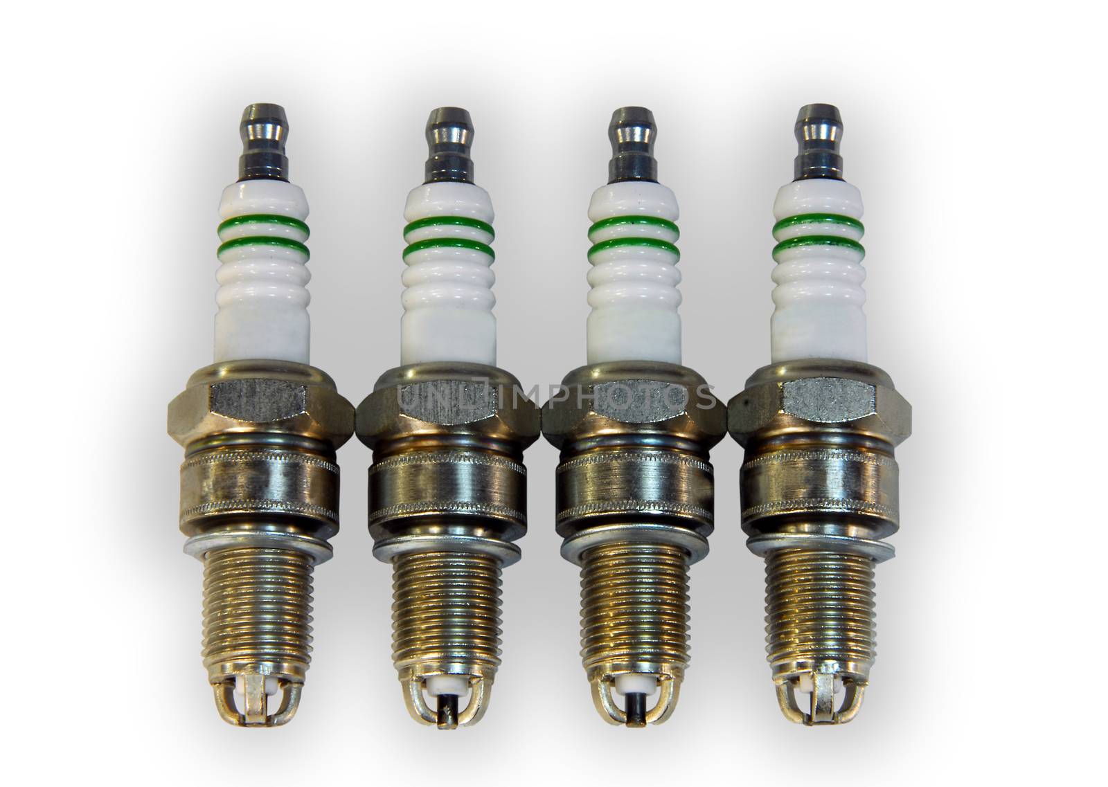 4 automobile spark plugs are on a white background