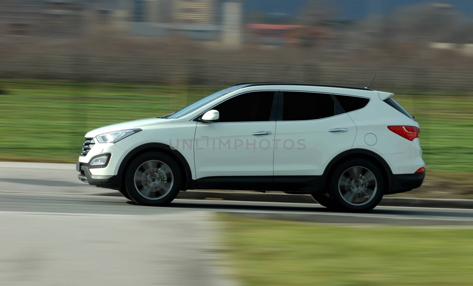 A panning shot of a speeding SUV