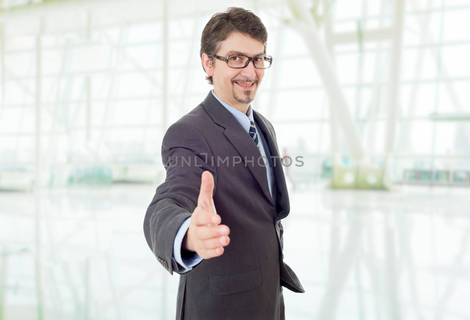 businessman in suit offering to shake the hand, at the office