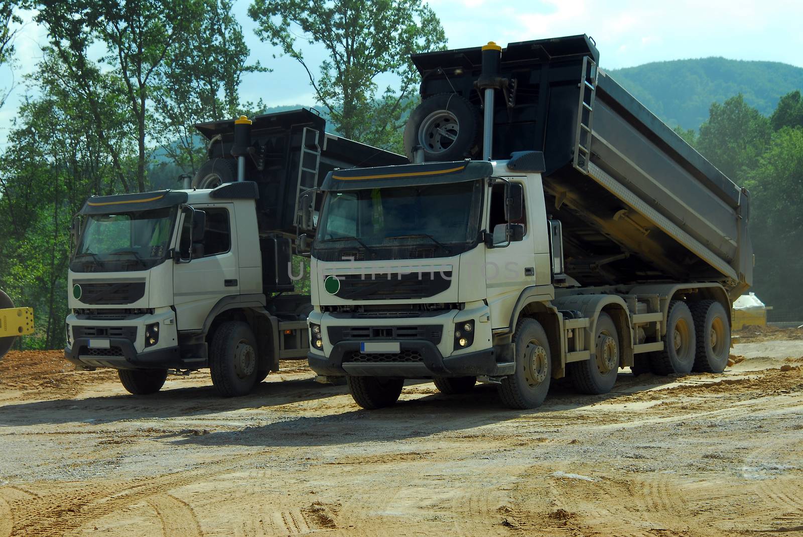 two big tipper trucks unloading land on the site