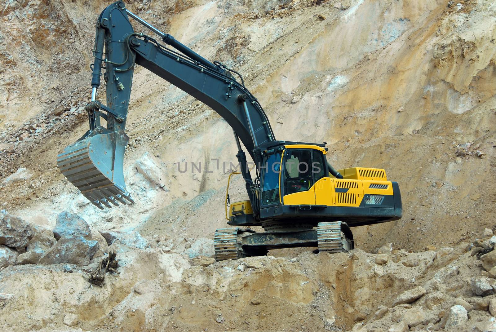 big yellow loader carries a large stone in the quarry