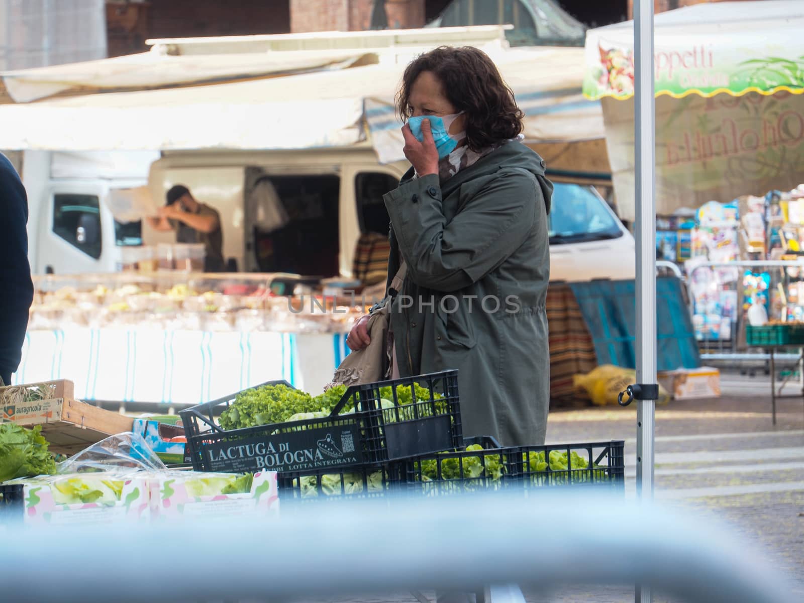 Cremona, Lombardy, Italy - 16 th may 2020 - People grocery shopping socially distance d in local biologic open air  food market wearing protection facial mask to prevent against contagion of coronavirus infection disease