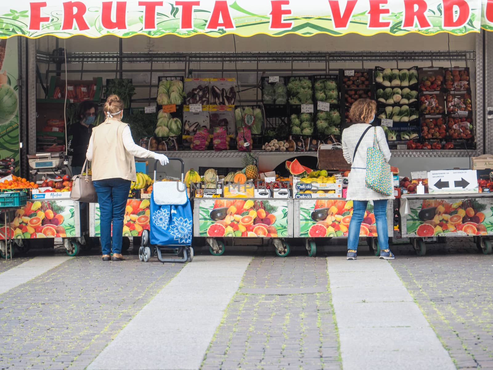 Cremona, Lombardy, Italy - 16 th may 2020 - People grocery shopping socially distance d in local biologic open air  food market wearing protection facial mask to prevent against contagion of coronavirus infection disease