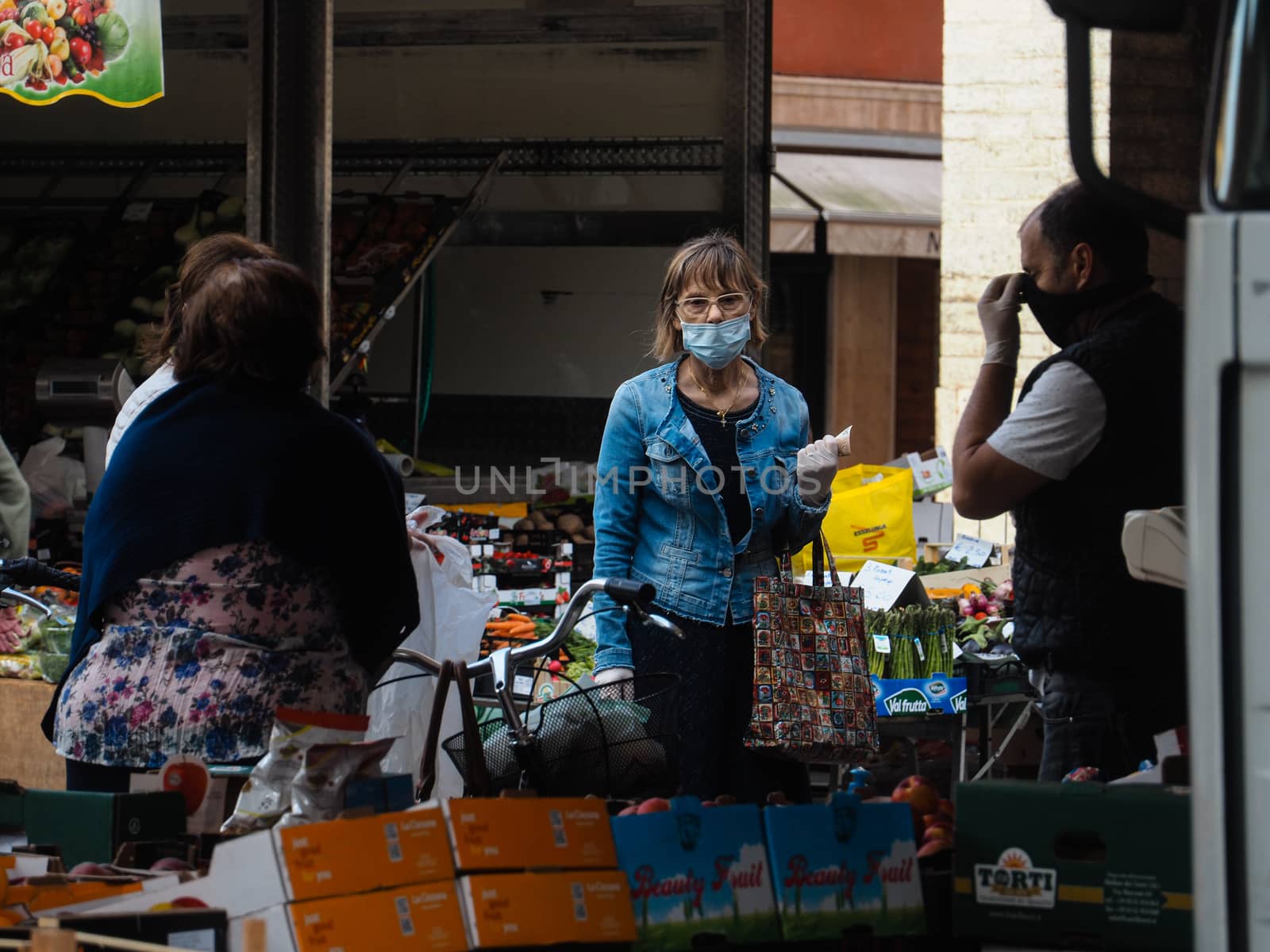 Cremona, Lombardy, Italy - 16 th may 2020 - People grocery shopping socially distance d in local biologic open air  food market wearing protection facial mask to prevent against contagion of coronavirus infection disease