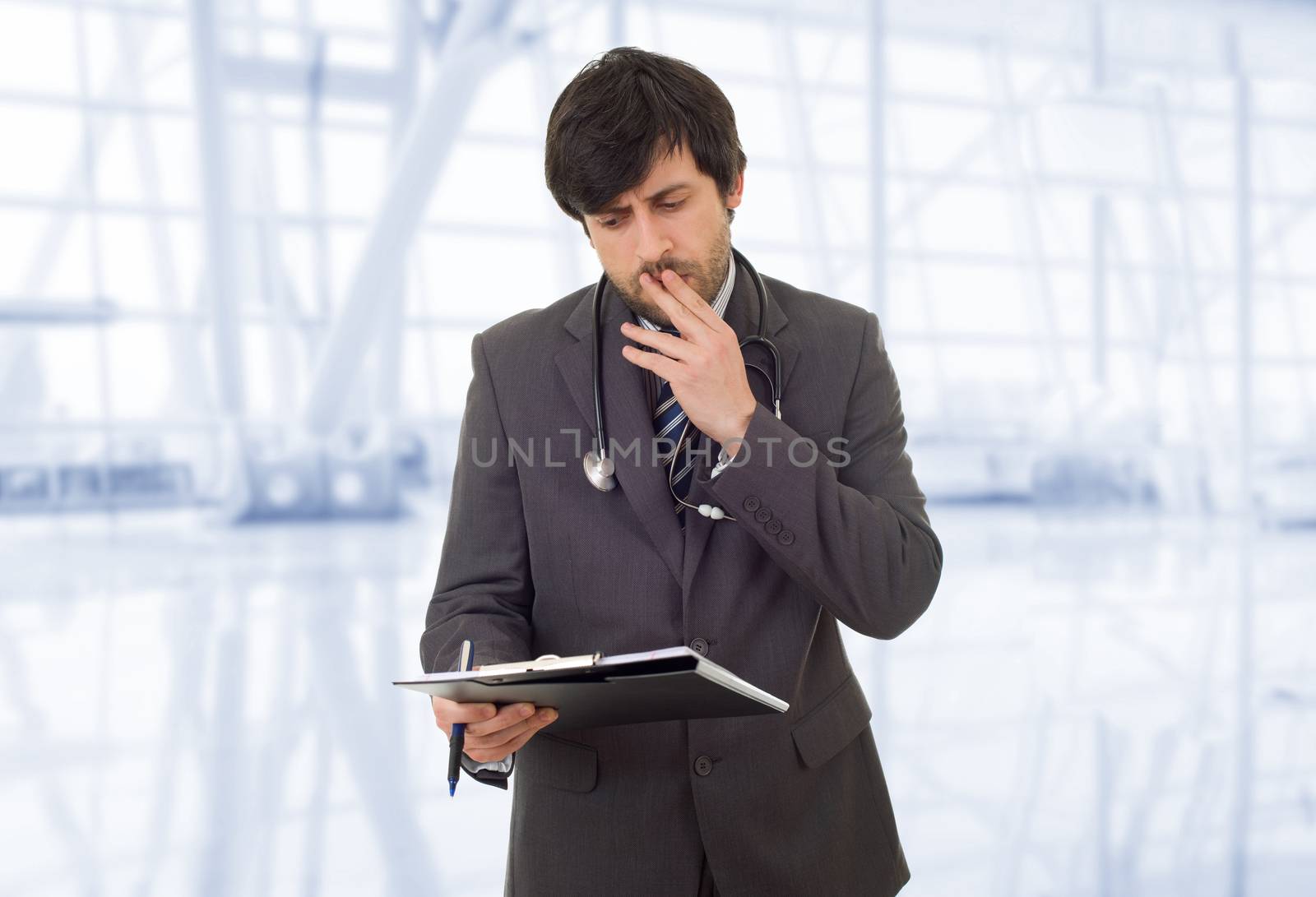 male doctor thinking with his notes, at the hospital