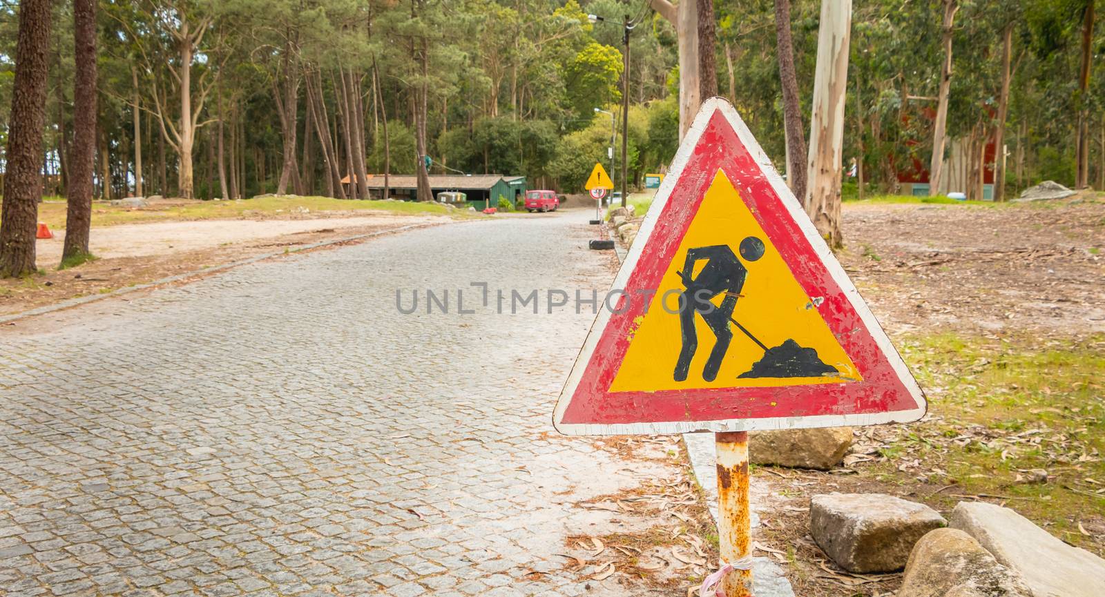 temporary road sign indicating work on a small road in the fores by AtlanticEUROSTOXX