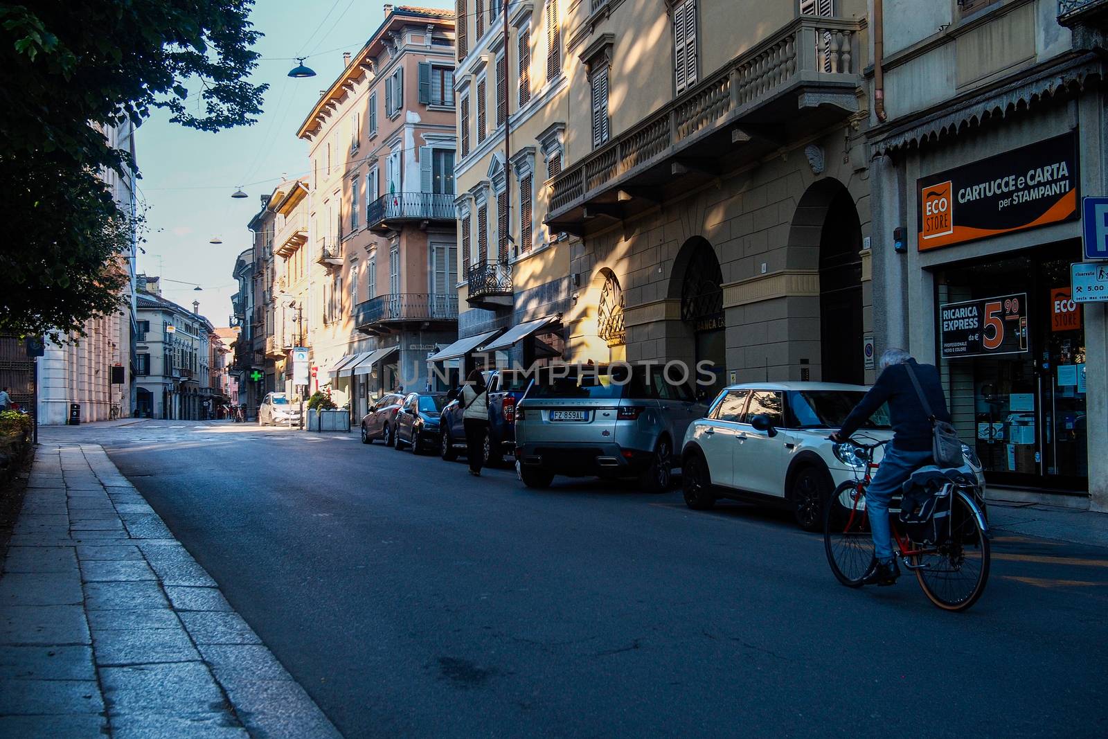 Cremona, Lombardy, Italy - April 30 th - May 1st 2020 - people biking walking dog walking in the center during covid 19  lockdown and economic crisis in Lombardy affected region.