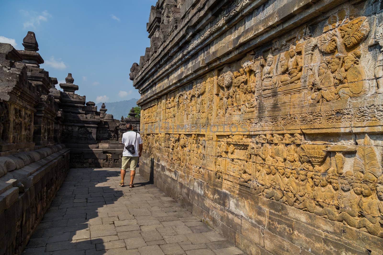 Man walking in the ancient Buddhist temple of Borobudur, in Magelang, Central Java, Indonesia