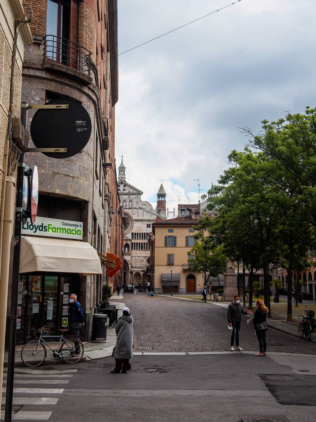 Cremona, Lombardy, Italy - April 30 th - May 1st 2020 - people biking walking dog walking in the center during covid 19  lockdown and economic crisis in Lombardy affected region.