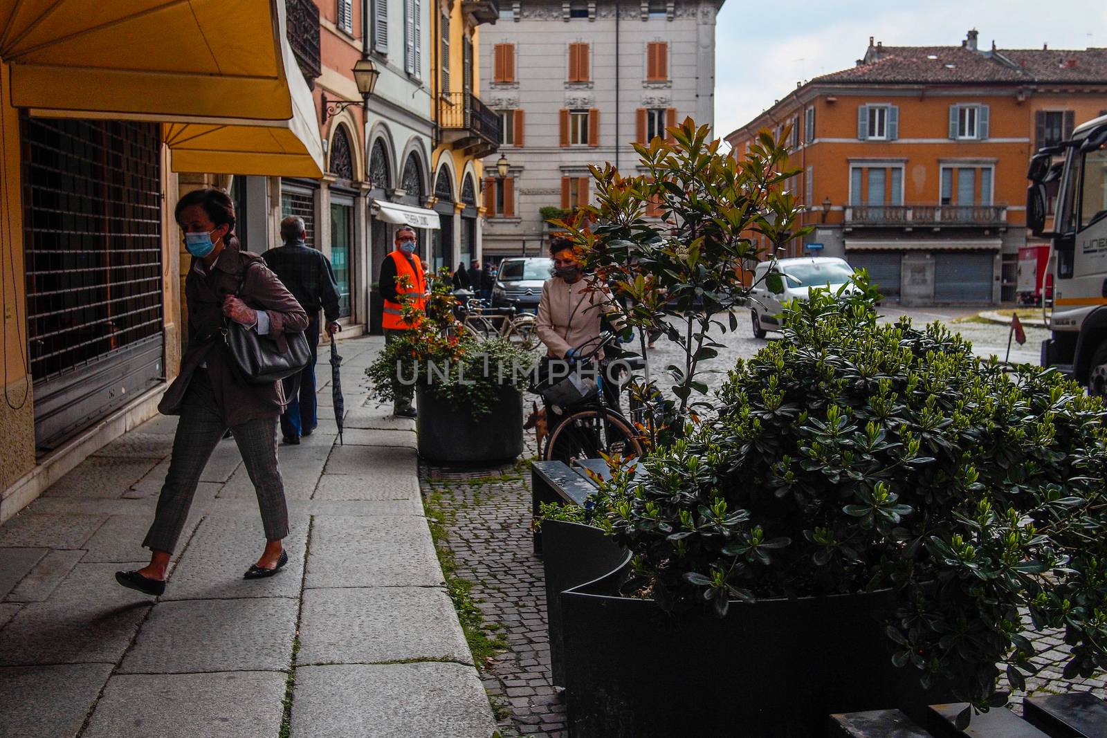 Cremona, Lombardy, Italy - April 30 th - May 1st 2020 - people biking walking dog walking in the center during covid 19  lockdown and economic crisis in Lombardy affected region.