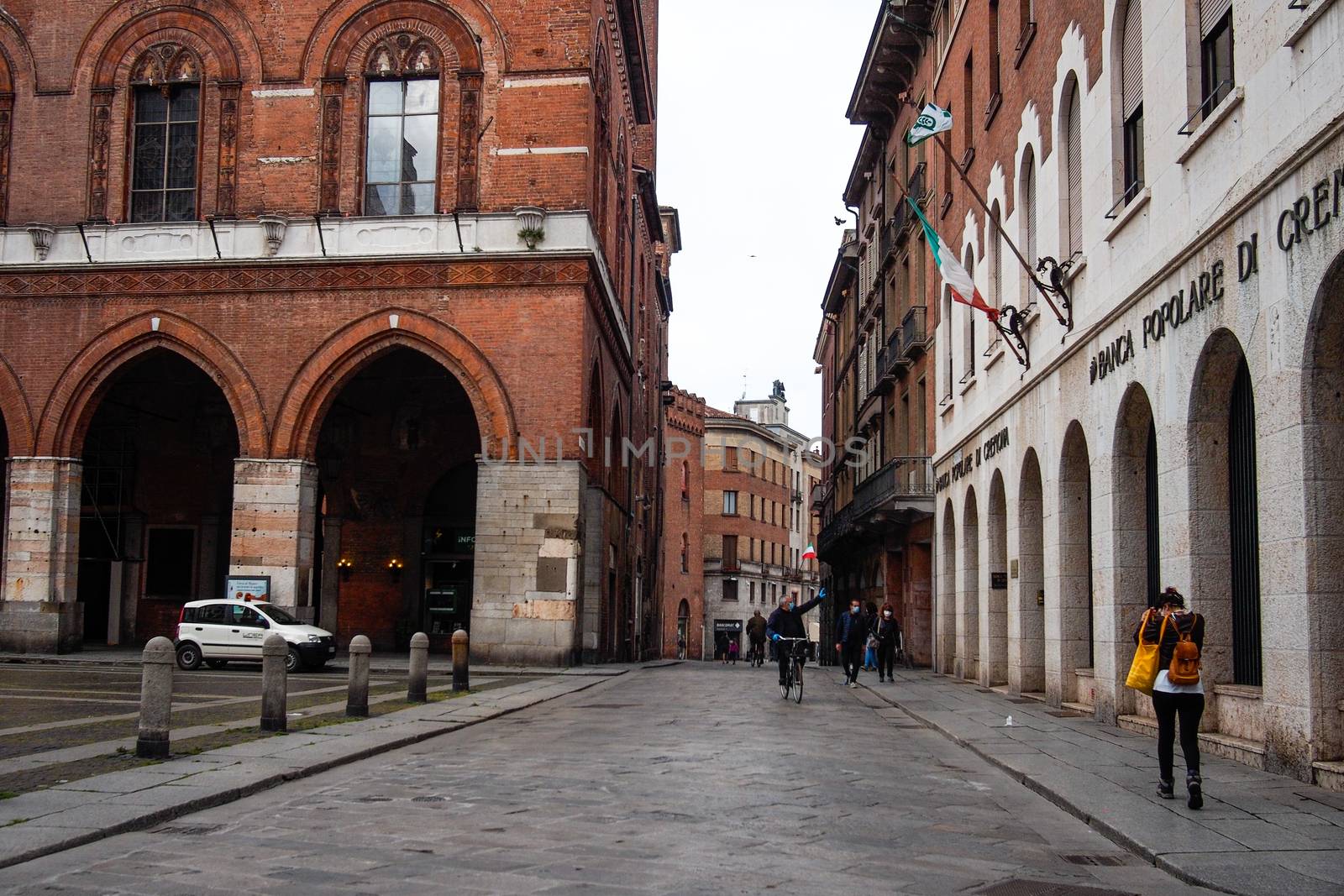 Cremona, Lombardy, Italy - April 30 th - May 1st 2020 - people biking walking dog walking in the center during covid 19  lockdown and economic crisis in Lombardy affected region.