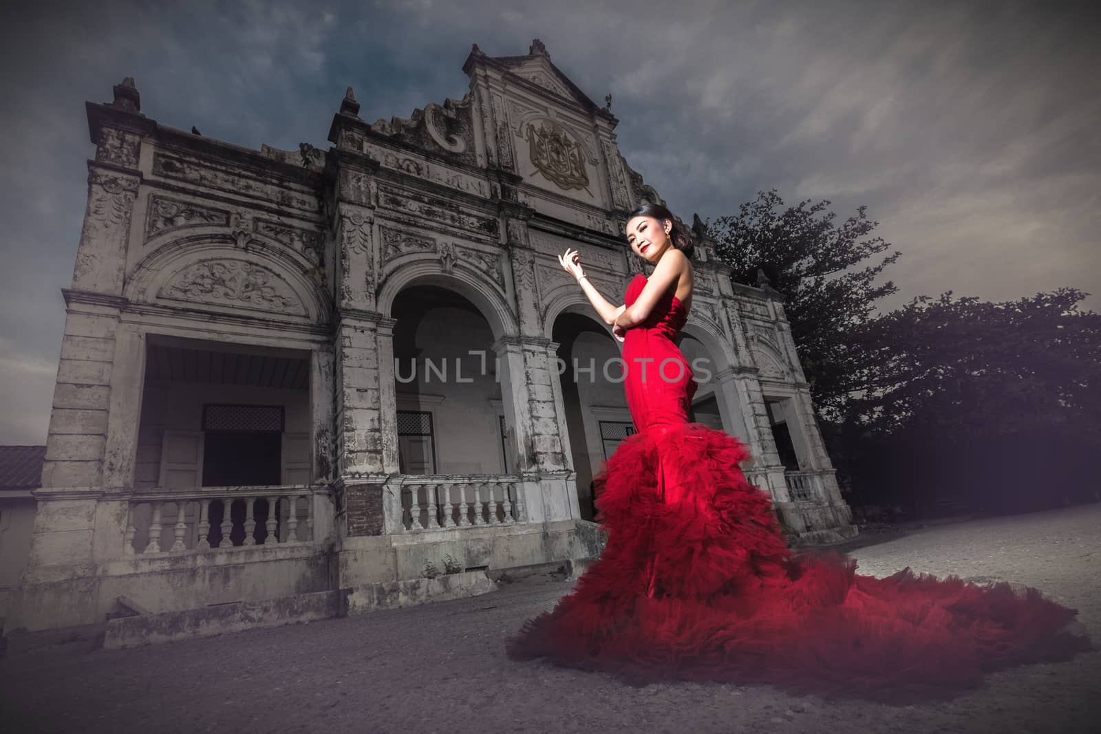 Beautiful woman wearing fashionable red dress by Surasak