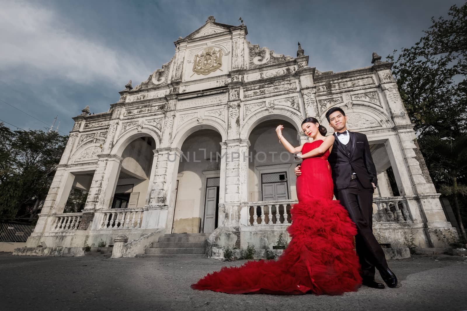 Man in black suit and Beautyful woman wearing fashionable red dr by Surasak
