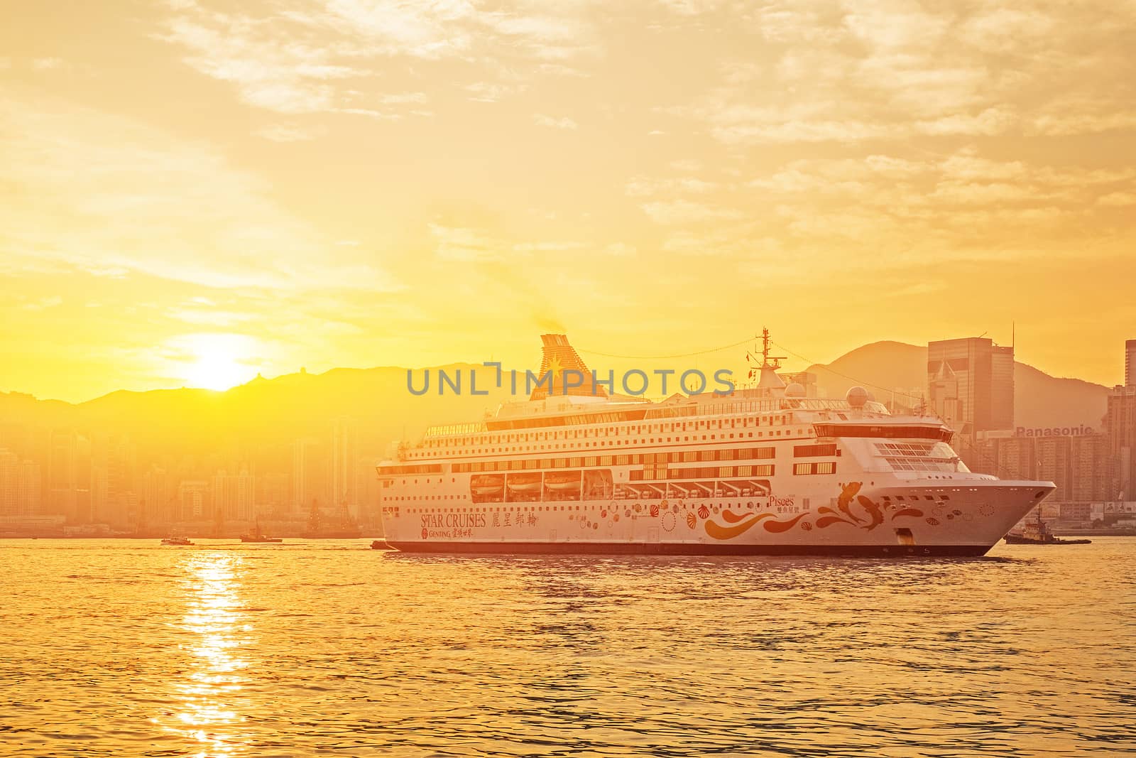 HONG KONG - JAN 13: Victoria Harbor on Jan 13, 2016 in Hong Kong. Big Cruise Ship departed from Ocean Terminal and drove across Victoria Harbor at sunrise.