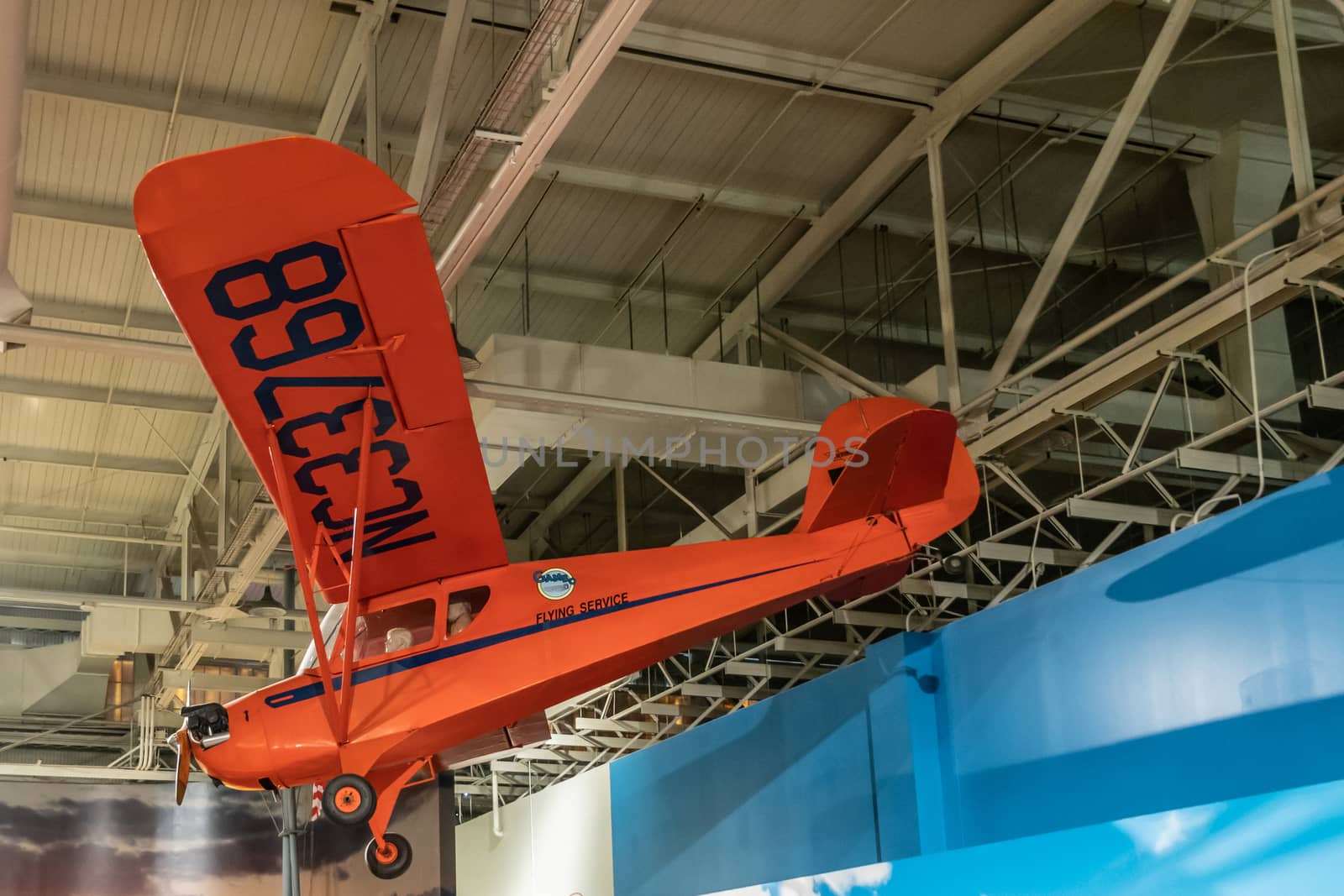 Oahu, Hawaii, USA. - January 10, 2020: Pearl Harbor Aviation Museum. small one-motor red Aeronca 65TC airplane hangs from the roof of hangar.