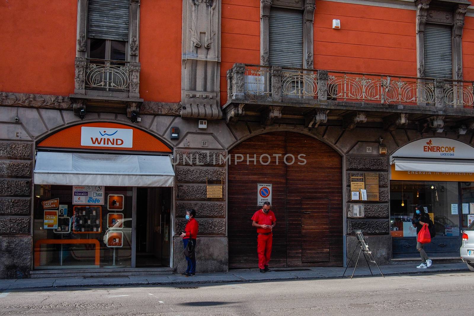 Cremona, Lombardy, Italy - May  5 6 7  2020 - man or woman walking or biking in deserted downtown  during covid outbreak lockdown phase 2