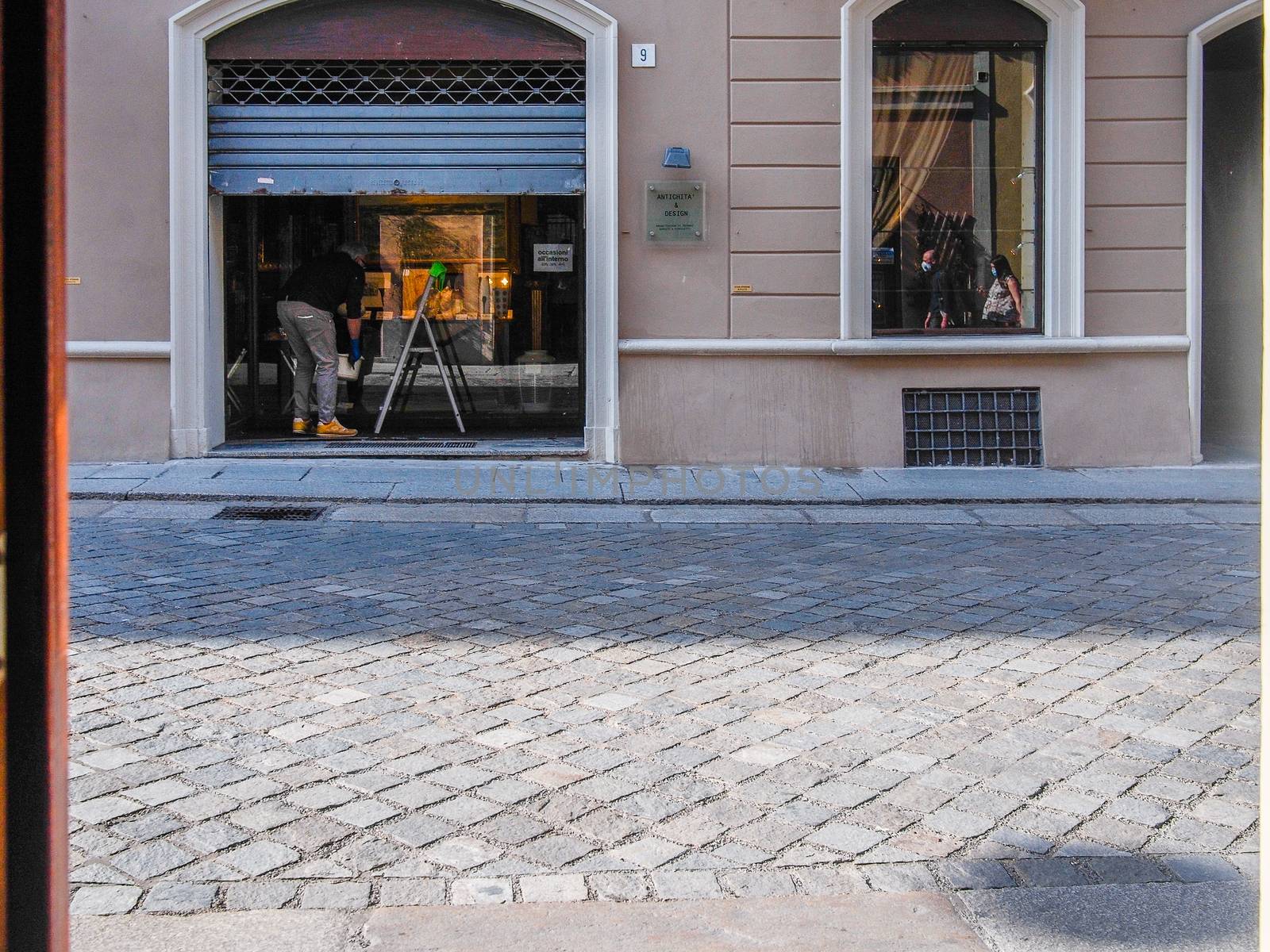 Cremona, Lombardy, Italy - May  5 6 7  2020 - man or woman walking or biking in deserted downtown  during covid outbreak lockdown phase 2