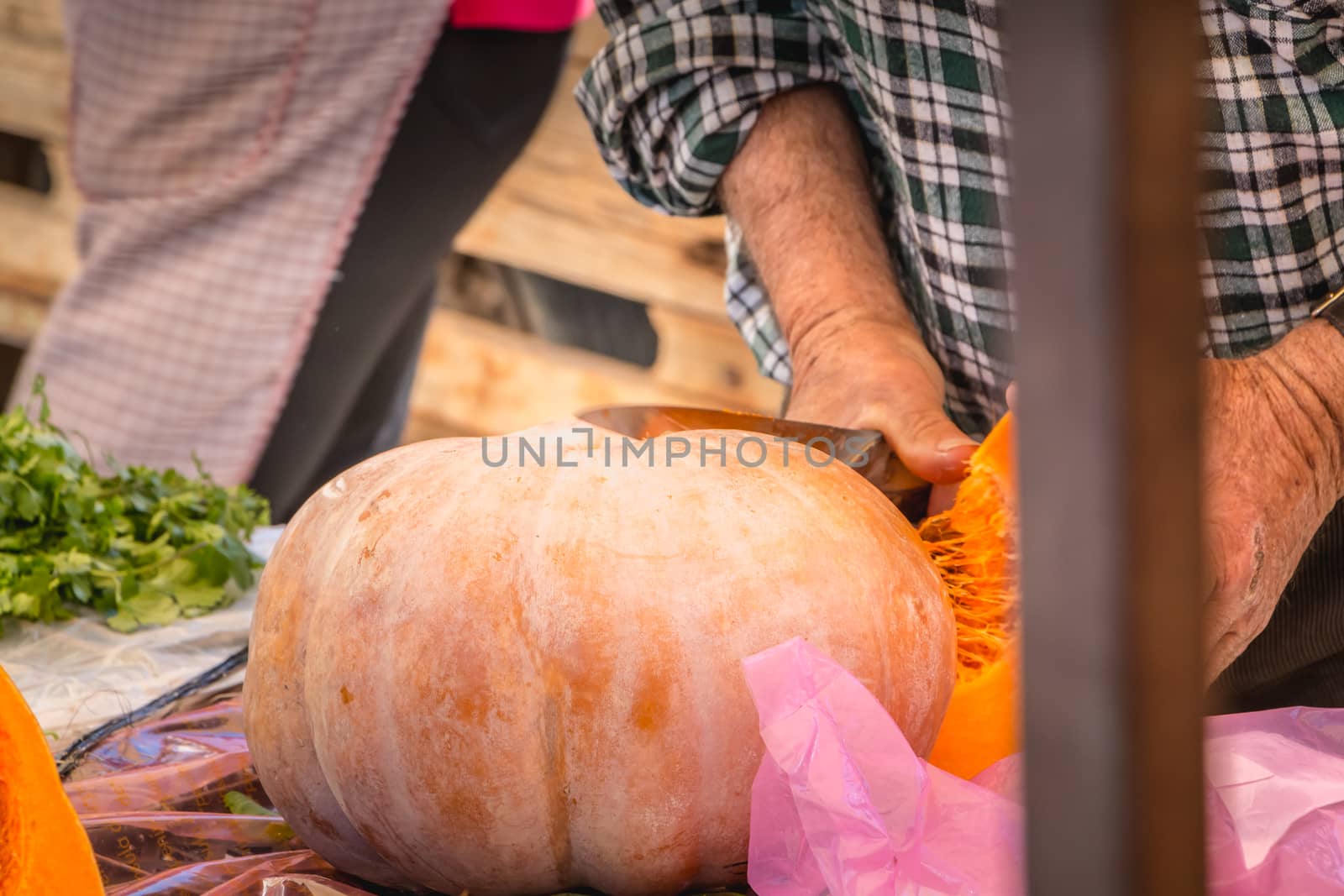 trader cuts a squash at the municipal market of quarteira by AtlanticEUROSTOXX