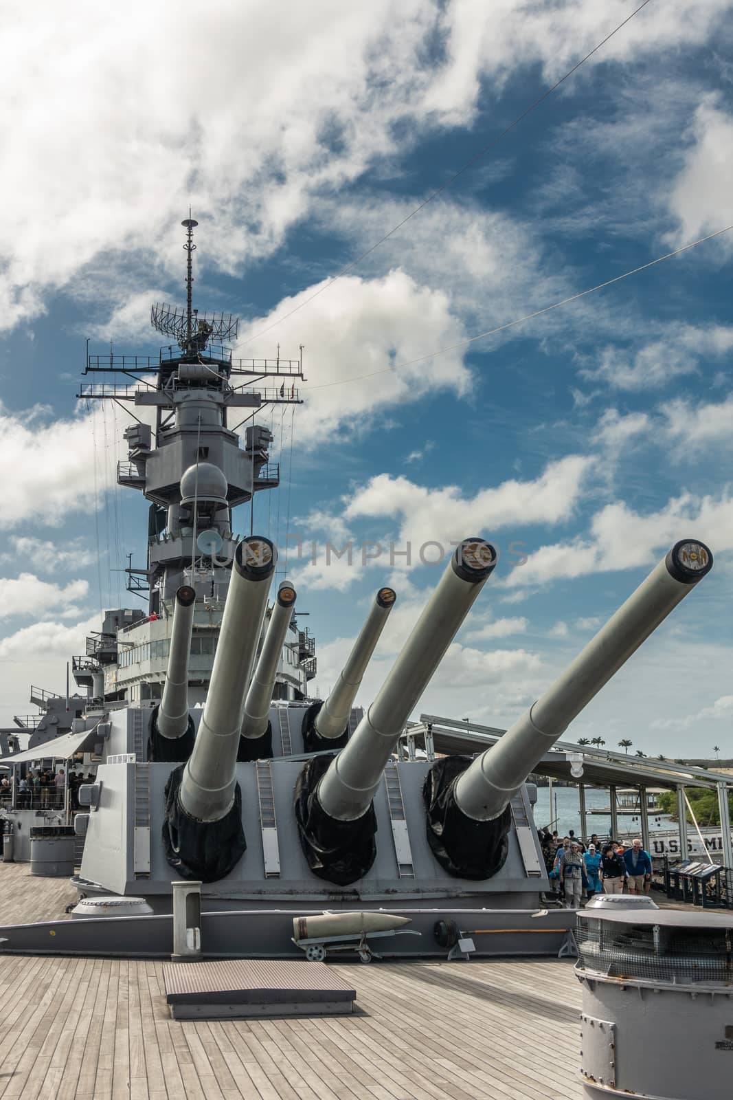 Oahu, Hawaii, USA. - January 10, 2020: Pearl Harbor. Multiple guns on bow and tower of USS Missouri Battle Ship under blue cloudscape. People on deck.